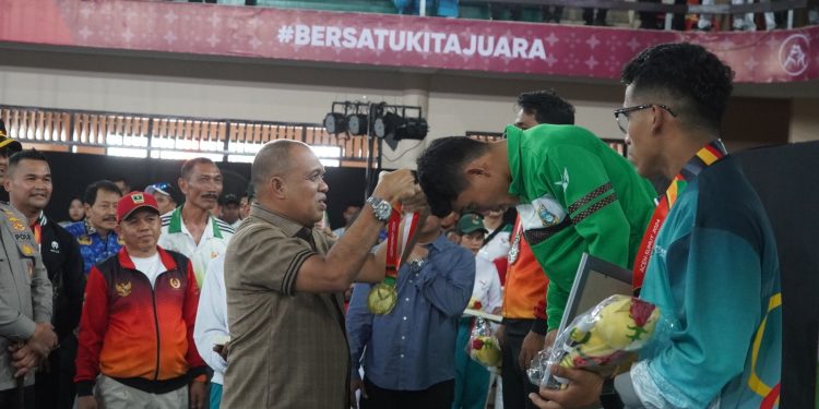 Pj Bupati Langkat Kalungkan Medali kepada Juara Cabang Olahraga Sambo