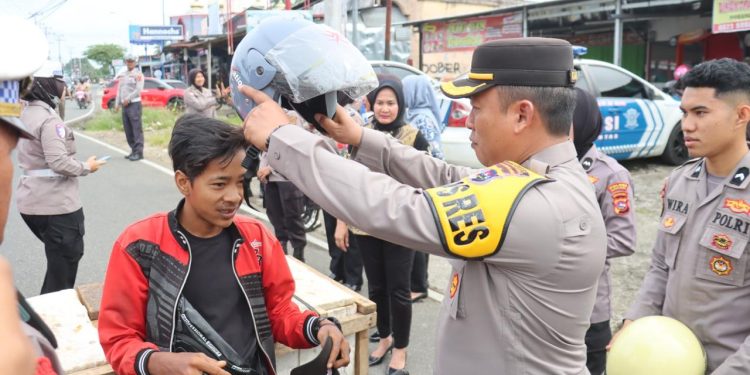 Kapolres Pasbar Bagikan Helm Gratis Bagi Pengendara
